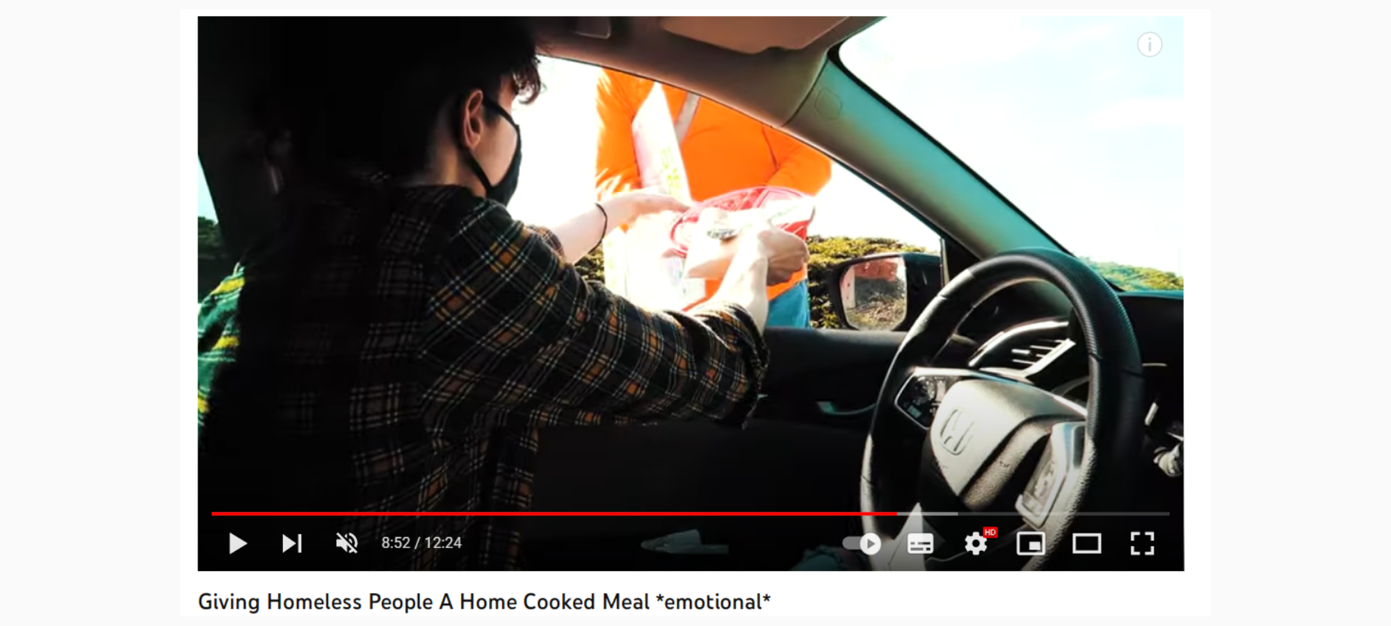 screenshot of youtube where a man hands out free food to people facing homelessness and films the process. He is sitting in a car and handing food out the window